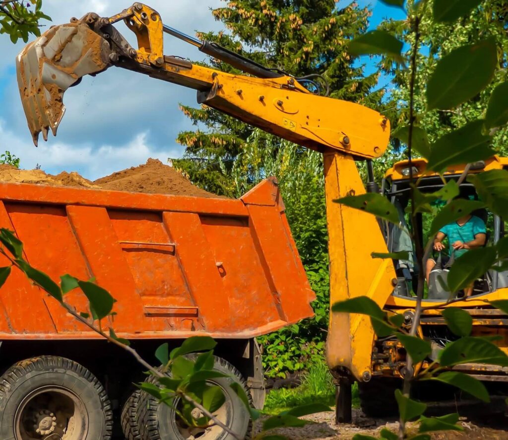 Loader removes excess dirt from a Kelowna driveway for efficient hauling.