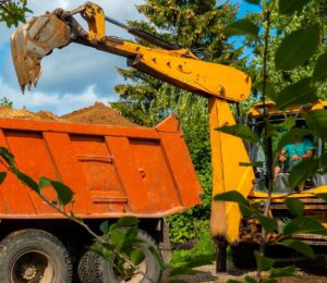 Loader handles dirt removal from a Kelowna driveway for efficient hauling